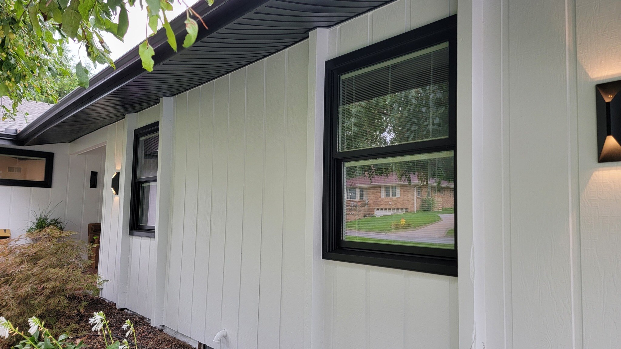 Exterior of house with white painted siding and black trim and soffitts.